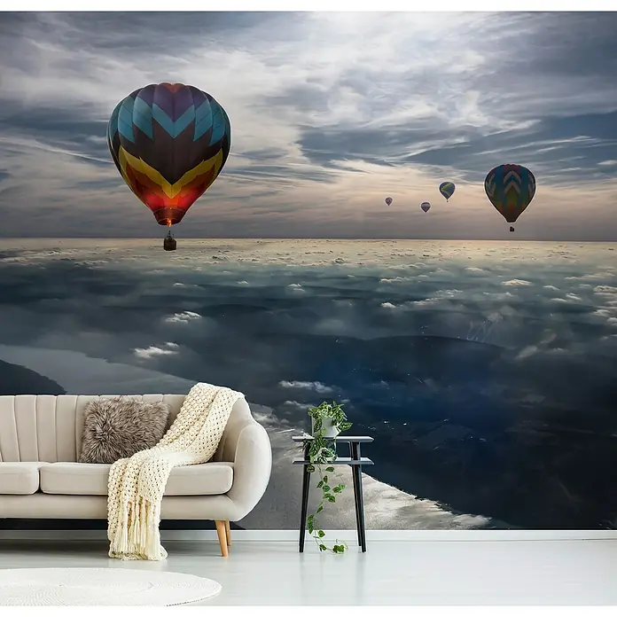 Papermoon Premium collection Fototapete Den Himmel küssen - B x H: 400 x 260 cm, Vlies - Wandbild mit Heißluftballons über einer weißen Couch und einem Beistelltisch mit Pflanze, das eine entspannende Atmosphäre schafft.