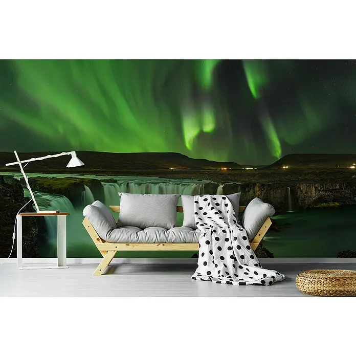 Papermoon Premium collection Fototapete Gödafoss Wasserfall Nordlichter - B x H: 300 x 223 cm, Vlies - Eine entspannende Szene mit einem bequemen Futon, einem Beistelltisch mit Lampe und einem atemberaubenden Hintergrund mit Nordlichtern und Wasserfällen.