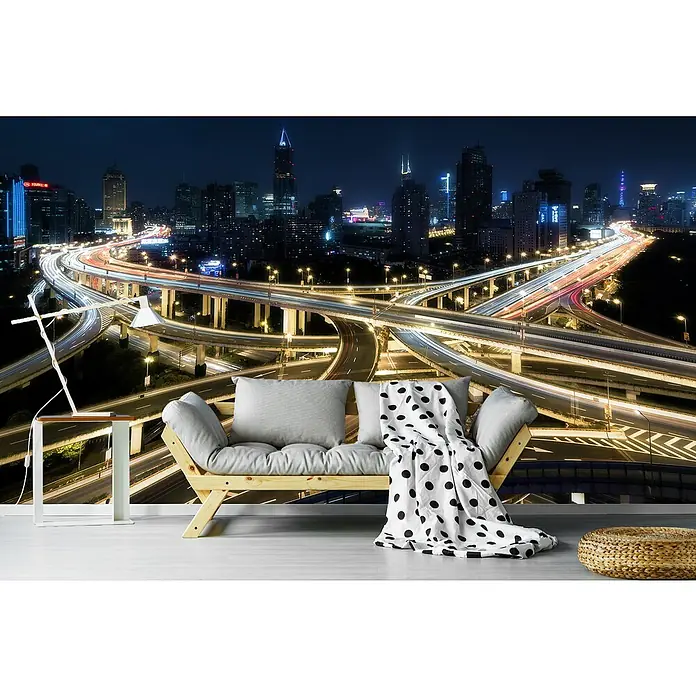 Papermoon Premium collection Fototapete Neun Drachen - B x H: 300 x 223 cm, Vlies - Ein gemütliches Sofa mit Kissen und Decke vor einem beeindruckenden Wandbild einer nächtlichen Skyline mit belebten Autobahnen.