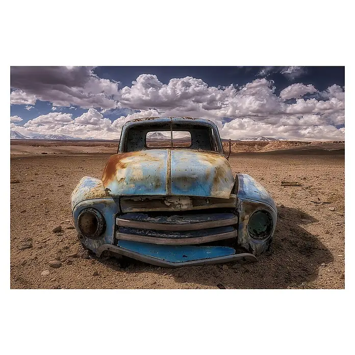 Papermoon Premium collection Fototapete Eindringen - B x H: 300 x 223 cm, Vlies - Ein verrosteter blauer Oldtimer-Truck steht verlassen in einer Wüstenlandschaft unter einem bewölkten Himmel.