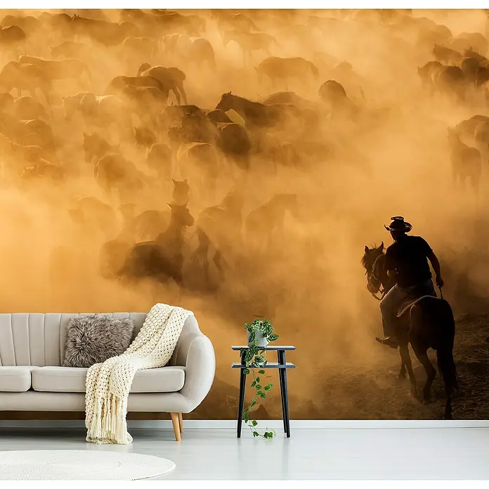 Papermoon Premium collection Fototapete Cappadocia wilde Pferde - B x H: 350 x 260 cm, Vlies - Ein Zimmer mit einem Wandbild, das eine Cowboy-Szene zeigt, mit Sofa, Tisch und Teppich.