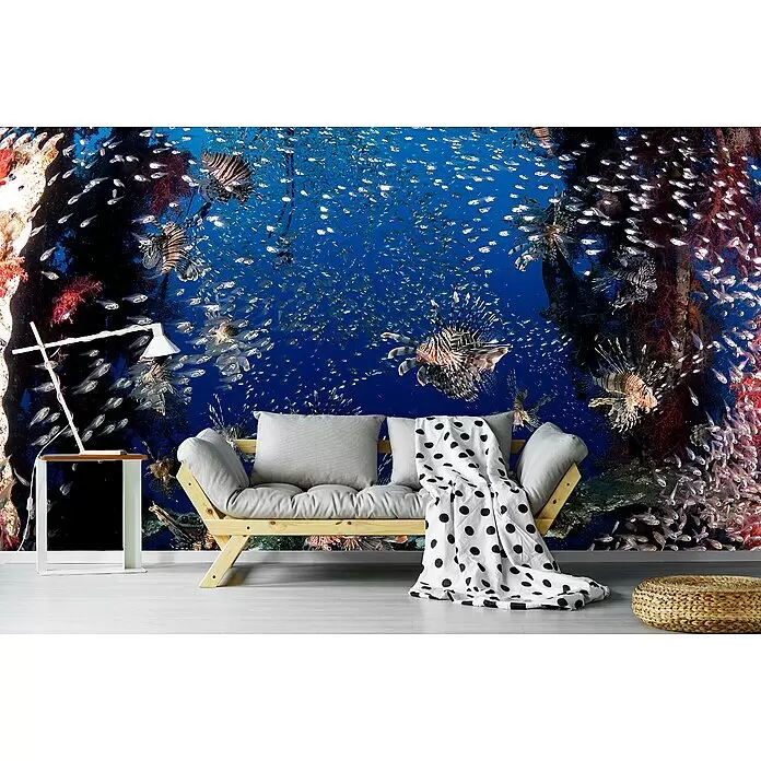 Papermoon Premium collection Fototapete Lionfish Party - B x H: 250 x 186 cm, Vlies - Hölzernes Futonsofa mit hellgrauen Kissen und schwarz-weiß gepunkteter Decke in einem Wohnraum.