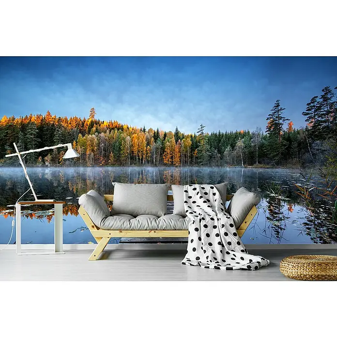 Papermoon Premium collection Fototapete Herbststeg - B x H: 300 x 223 cm, Vlies - Einrichtungsidee mit einer Couch, einem Beistelltisch mit Lampe und einem Pouf vor einer Fototapete mit Herbstlandschaft.