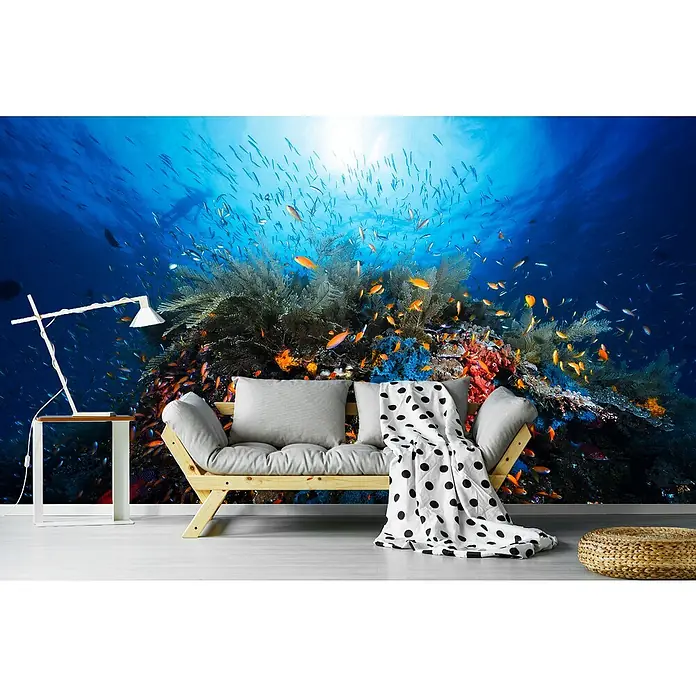Papermoon Premium collection Fototapete Apnoe - B x H: 300 x 223 cm, Vlies - Wohnzimmer mit Fototapete einer Unterwasserwelt und einem hellen Sofa. Die Tapete zeigt Fische und Korallen.