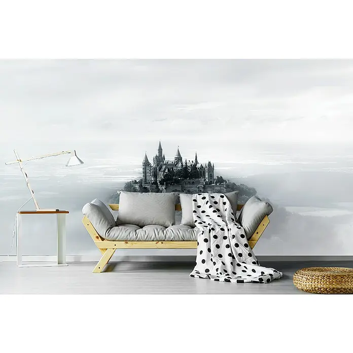 Papermoon Premium collection Fototapete Hohenzollern - B x H: 450 x 280 cm, Vlies - Ein Zimmer mit einem Futon-Sofa, einer Lampe und einem kleinen Beistelltisch, dekoriert mit einer auffälligen Burgtapete für einen märchenhaften Look.