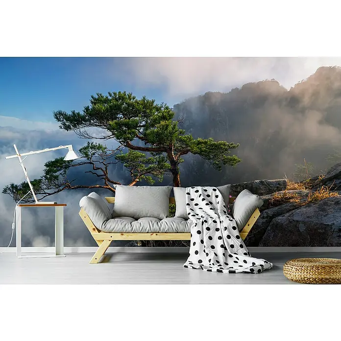 Papermoon Premium collection Fototapete Traumtänzerin - B x H: 200 x 149 cm, Vlies - Dieses Bild zeigt eine Couch mit Kissen und einer Decke mit Polka Dots vor einer Landschaft mit Bäumen und Bergen.