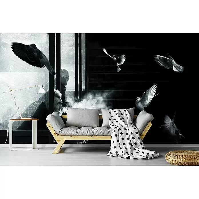 Papermoon Premium collection Fototapete Der Mann der Tauben - B x H: 500 x 280 cm, Vlies - Helles Holz Futonsofa mit grauen Kissen und einer weiß-gepunkteten Decke in einem Wohnzimmer.