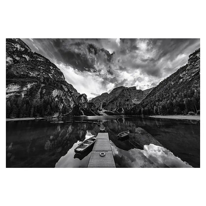 Papermoon Premium collection Fototapete Braies 'Graustufen' - B x H: 400 x 260 cm, Vlies - Schwarzweißbild von Booten am See mit Bergen im Hintergrund und dramatischem Himmel, die ruhige und friedliche Atmosphäre widerspiegeln.
