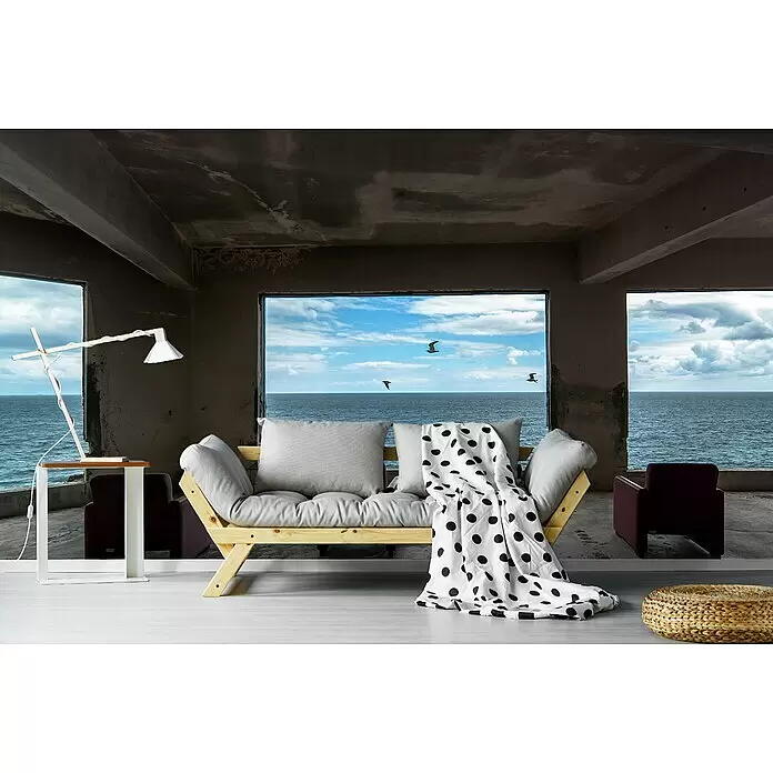 Papermoon Premium collection Fototapete Kino - B x H: 450 x 280 cm, Vlies - Helles Holzsofa mit grauen Kissen und gepunkteter Decke in minimalistischem Raum mit Meerblick.