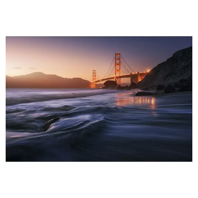 Papermoon Premium collection Fototapete Goldener Strand - B x H: 300 x 223 cm, Vlies - Blick auf die Golden Gate Bridge bei Dämmerung mit sanften Wellen im Vordergrund, die das Licht der Brücke reflektieren.