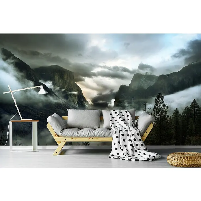 Papermoon Premium collection Fototapete Obertalmorgen - B x H: 450 x 280 cm, Vlies - Wandbild mit einer dramatischen Berglandschaft hinter einem Holzbett mit grauen Kissen und einer gepunkteten Decke.