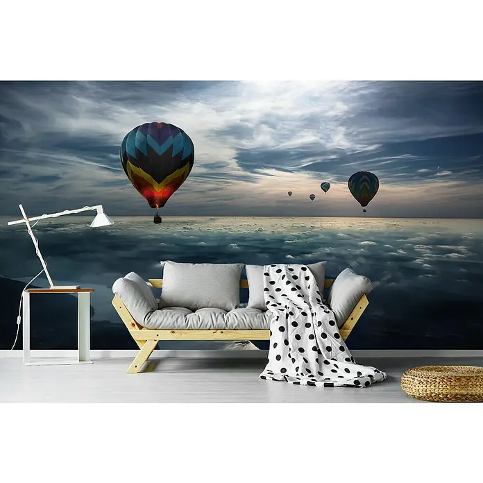 Papermoon Premium collection Fototapete Den Himmel küssen - B x H: 400 x 260 cm, Vlies - Wandbild mit Heißluftballons über Wolken, darunter ein Holzbett mit Kissen und eine Lampe, die eine ruhige und verträumte Atmosphäre schafft.