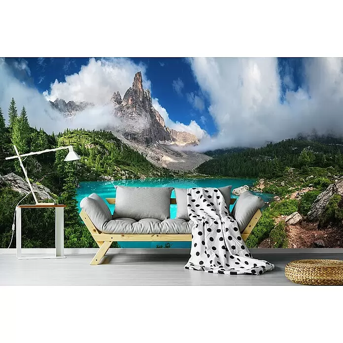 Papermoon Premium collection Fototapete Lago di Sorapis Venetien - B x H: 300 x 223 cm, Vlies - Holz-Futonsofa mit hellgrauen Kissen und gepunkteter Decke vor einem Bergseewandbild.