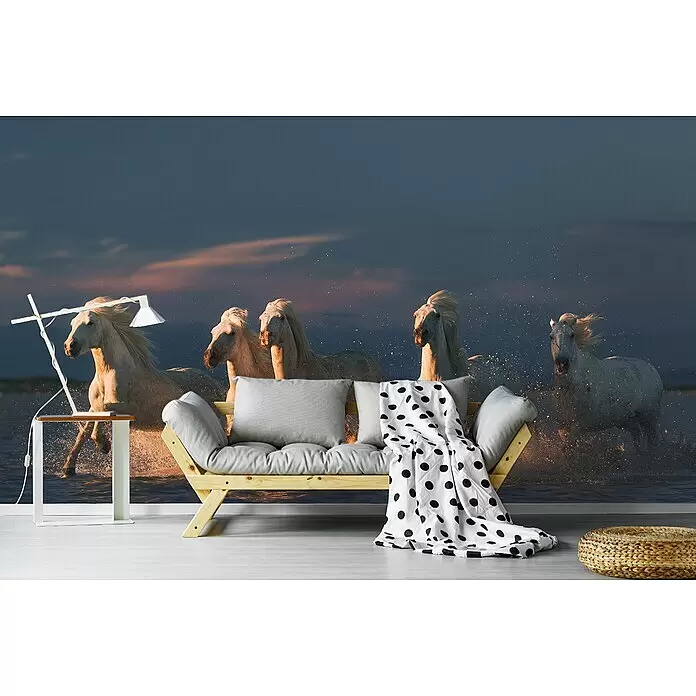 Papermoon Premium collection Fototapete Pferde im Meer - B x H: 300 x 223 cm, Vlies - Ein hellgraues Futonsofa mit Naturholzrahmen und einer schwarz-weiß gepunkteten Decke in einem Raum mit Pferdewandbild.