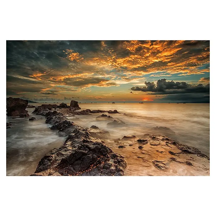 Papermoon Premium collection Fototapete Wütender Strand - B x H: 450 x 280 cm, Vlies - Sonnenuntergang über dem Meer mit Felsen im Vordergrund. Farbenprächtiger Himmel und ruhige Wasseroberfläche mit weichen Übergängen.