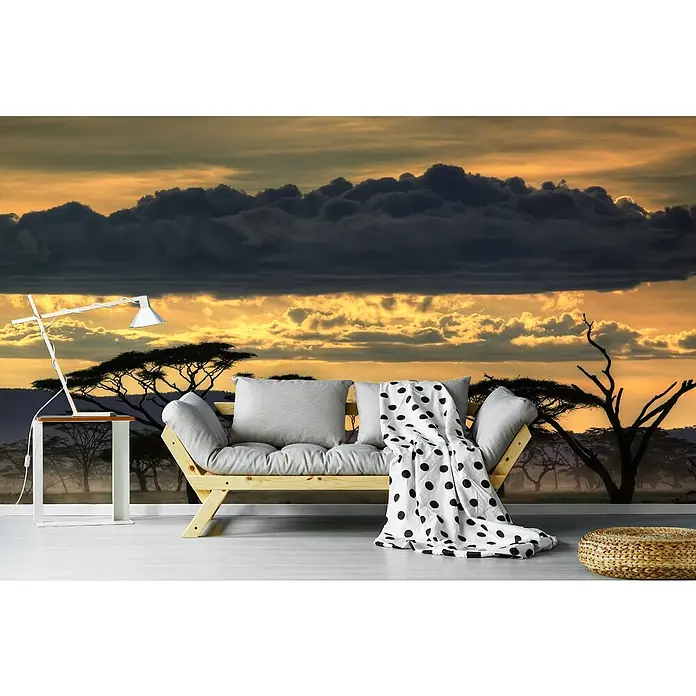 Papermoon Premium collection Fototapete Pinien in Savanne - B x H: 450 x 280 cm, Vlies - Dieses Bild zeigt ein modernes Wohnzimmer mit einer Couch, einem Beistelltisch und einem Hocker vor einem afrikanischen Landschaftswandbild.