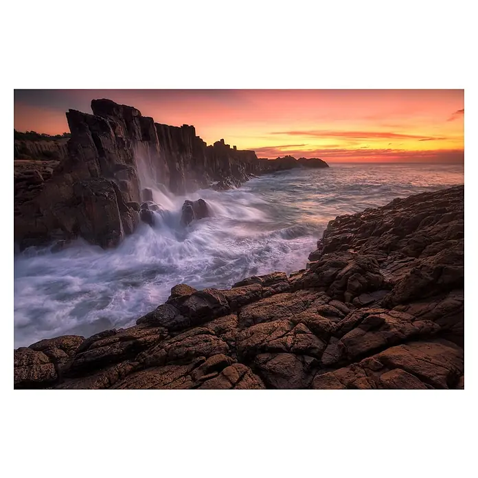 Papermoon Premium collection Fototapete Wand am Meer - B x H: 450 x 280 cm, Vlies - Küstenlandschaft bei Sonnenuntergang mit dramatischen Felsen und Gischt, die für einen dynamischen und malerischen Effekt sorgt.