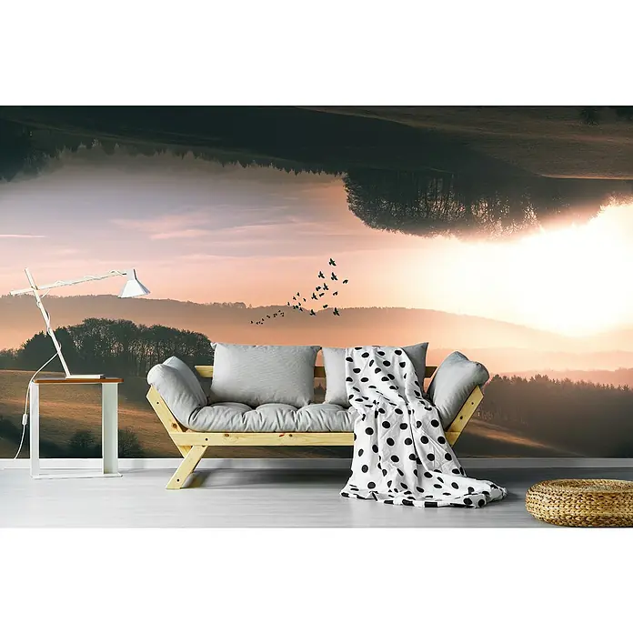 Papermoon Premium collection Fototapete Interplana - B x H: 250 x 186 cm, Vlies - Ein gemütliches Wohnzimmer mit einem hellen Holzbettsofa, grauen Kissen und einer gepunkteten Decke vor einer Landschaftstapete.