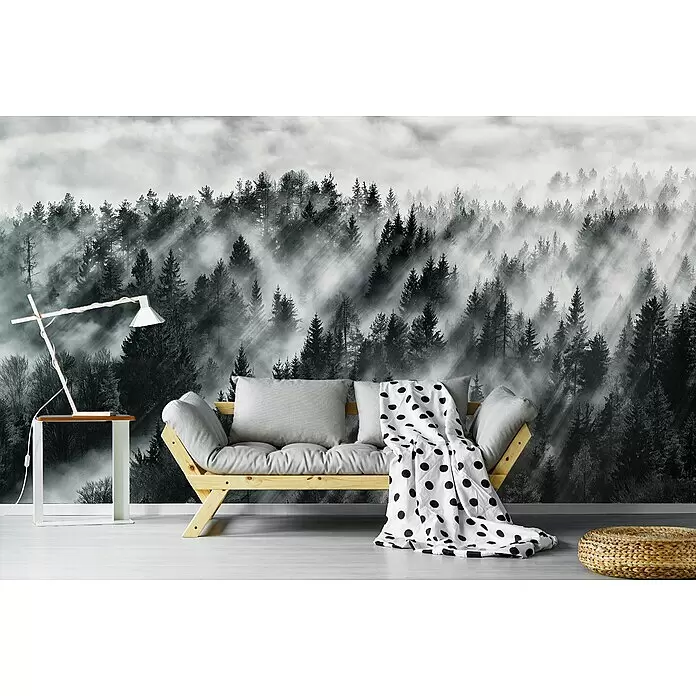 Papermoon Premium collection Fototapete Baumspitzen - B x H: 300 x 223 cm, Vlies - Holzbettsofa mit hellgrauen Kissen und einer gepunkteten Decke in einem Raum mit Waldmotiv an der Wand.