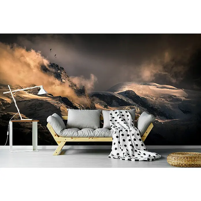 Papermoon Premium collection Fototapete Neblige Bergschichten - B x H: 450 x 280 cm, Vlies - Das Bild zeigt ein stilvolles Sofa mit einem Polka-Dot-Überwurf und einer Lampe vor einer beeindruckenden Bergkulisse.
