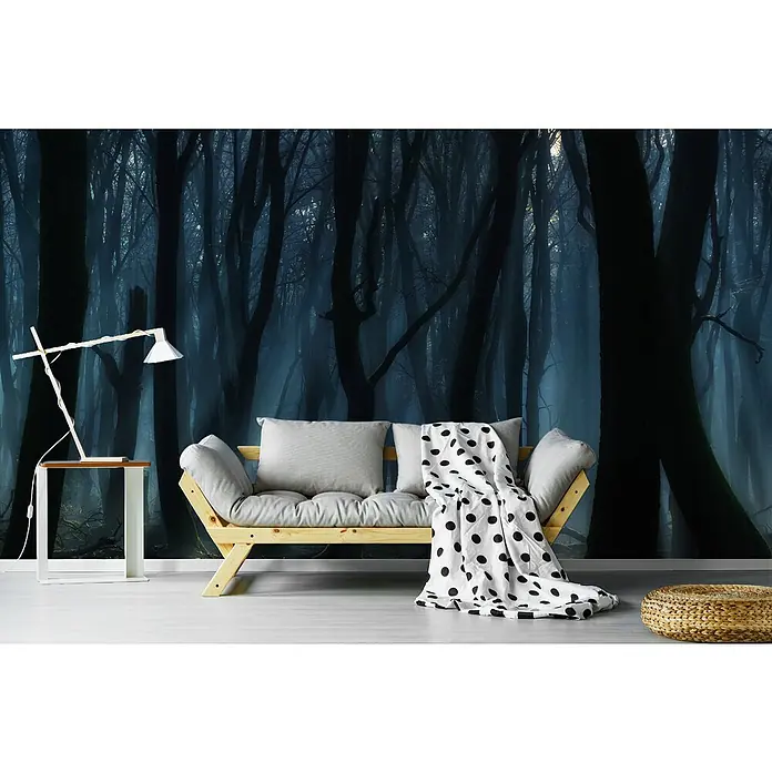 Papermoon Premium collection Fototapete Tanzbäume - B x H: 400 x 260 cm, Vlies - Wohnzimmer mit einer stylischen Lampe und einem hellen Sofa mit Decke vor einer dunklen Waldtapete.