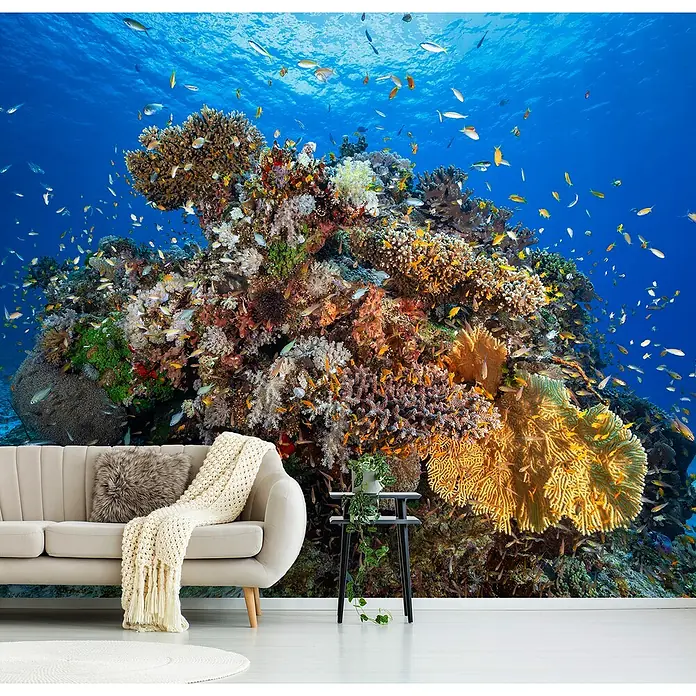 Papermoon Premium collection Fototapete Unterwasserwelt - B x H: 300 x 223 cm, Vlies - Ein Wohnzimmer mit einer Korallenriff-Tapete, die ein lebendiges und farbenfrohes Unterwasserparadies zeigt.