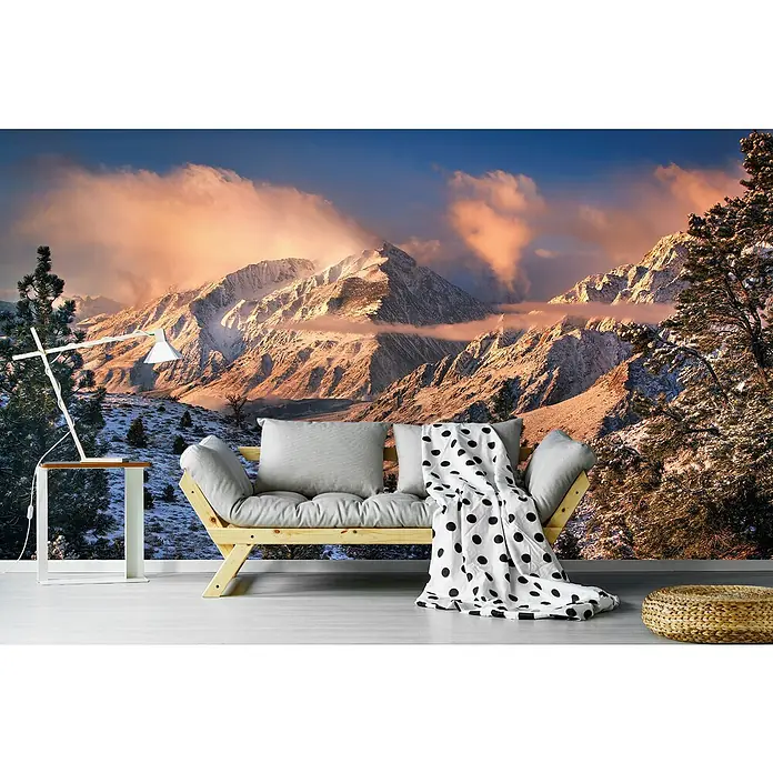 Papermoon Premium collection Fototapete Berglicht - B x H: 500 x 280 cm, Vlies - Gemütliches Zimmer mit einem stilvollen Futon-Sofa, dekoriert mit Kissen und einer gepunkteten Decke, vor einer beeindruckenden Bergkulisse.