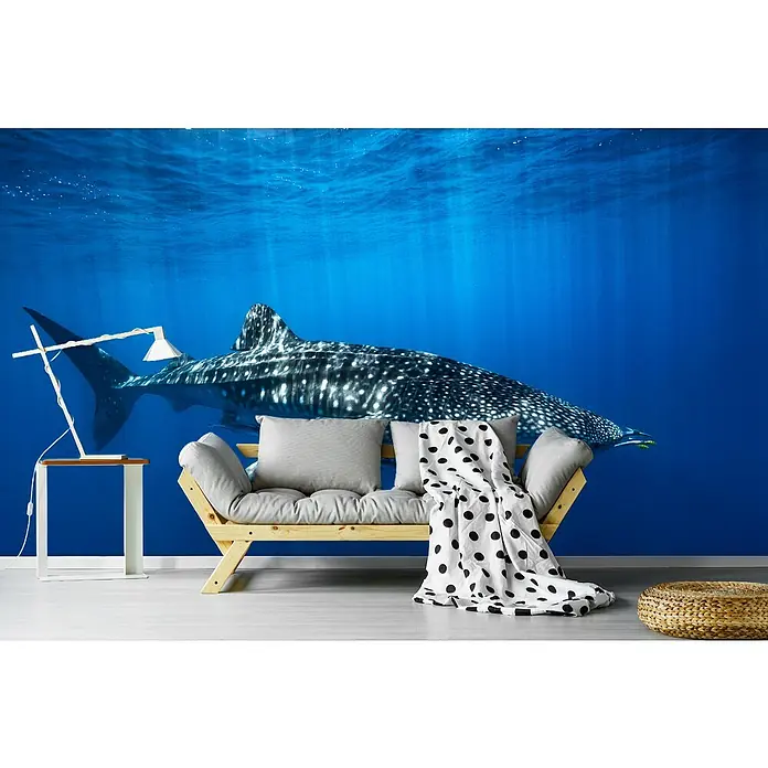 Papermoon Premium collection Fototapete Walhai in Blau - B x H: 500 x 280 cm, Vlies - Modernes Wohnzimmer mit einem stylischen Holzbettsofa, einem Beistelltisch mit Lampe und einer Fototapete mit einem Walhai im Hintergrund.