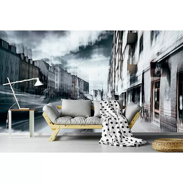 Papermoon Premium collection Fototapete Leben In Kopenhagen - B x H: 250 x 186 cm, Vlies - Ein helles Holzsofa mit grauen Kissen und einer weiß gepunkteten Decke in einem Raum mit Wandbild einer Stadtstraße.
