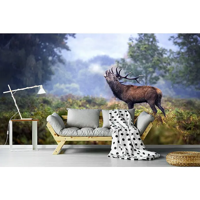 Papermoon Premium collection Fototapete Im Regen schreien - B x H: 300 x 223 cm, Vlies - Einladende Sofaecke mit Kissen, Decke und einem Beistelltisch mit Lampe vor einer Waldtapete mit Hirschmotiv.