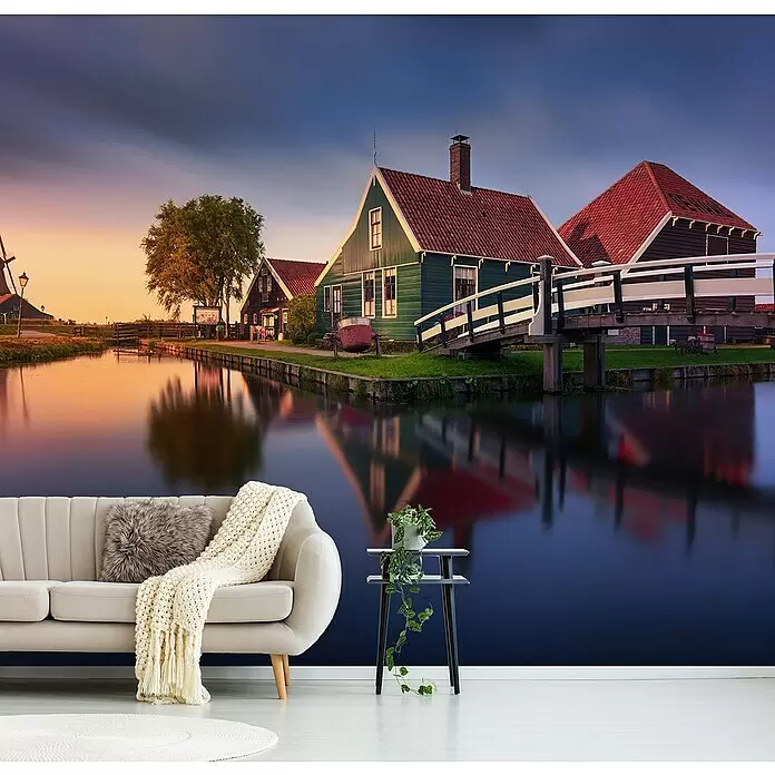 Papermoon Premium collection Fototapete Haus an der Zaan - B x H: 300 x 223 cm, Vlies - Eine Wandtapete mit einer ruhigen Kanalszene mit traditionellen grünen Häusern und einer Brücke bei Sonnenuntergang, die ein modernes Wohnzimmer verschönert.