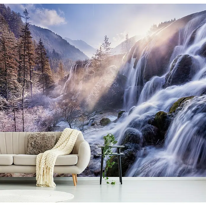Papermoon Premium collection Fototapete Berglandschaft - B x H: 250 x 186 cm, Vlies - Elegantes Wohnzimmer mit einer bequemen Couch, einem dekorativen Beistelltisch und einem atemberaubenden Wasserfall-Wandbild im Hintergrund.
