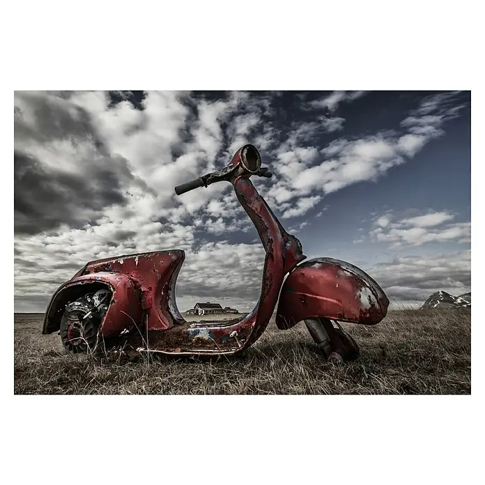 Papermoon Premium collection Fototapete Gerahmte Erinnerung - B x H: 250 x 186 cm, Vlies - Ein verrosteter roter Motorroller steht im Feld unter einem bewölkten Himmel. Ein verlassenes Gebäude ist im Hintergrund zu sehen.