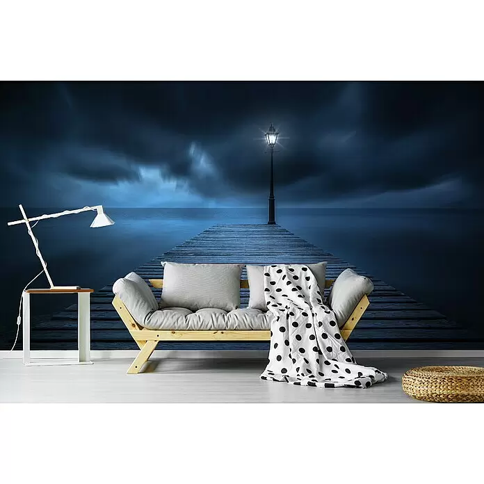 Papermoon Premium collection Fototapete Erste Lichter - B x H: 500 x 280 cm, Vlies - Holzsofa mit grauen Polstern und gepunkteter Decke, in modernem Raum vor dramatischer Pier- und Meeres-Wandmalerei.