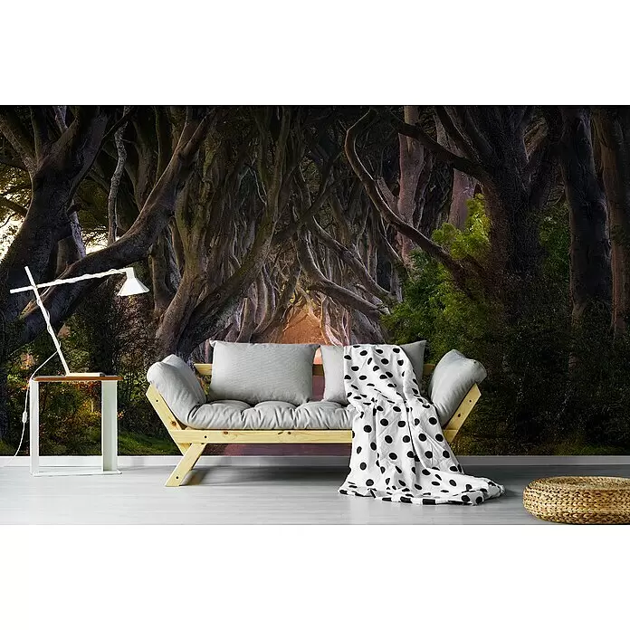 Papermoon Premium collection Fototapete Glühenden Hedges - B x H: 200 x 149 cm, Vlies - Ein gemütlicher Sitzbereich mit hellem Holzsofa, grauen Kissen und gepunkteter Decke. Eine weiße Lampe auf einem Tisch und ein geflochtener Hocker vervollständigen den Look.