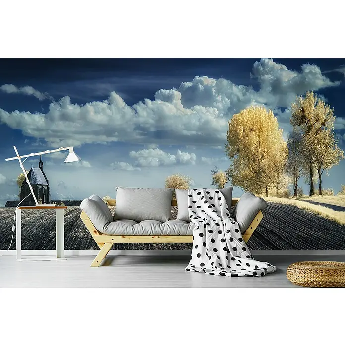 Papermoon Premium collection Fototapete Irenkowo - B x H: 400 x 260 cm, Vlies - Wohnraum mit Couch, Tischlampe und Wandbild mit Feld-, Baum- und Wolkenmotiven für eine entspannte Atmosphäre im Raum.