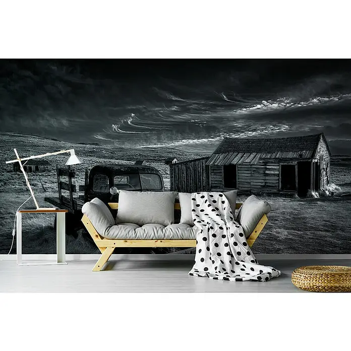 Papermoon Premium collection Fototapete Kein Gold mehr - B x H: 350 x 260 cm, Vlies - Eine stilvolle Szene mit einem Sofa, einer Lampe und einem Hocker vor einer beeindruckenden Schwarzweiß-Tapete.