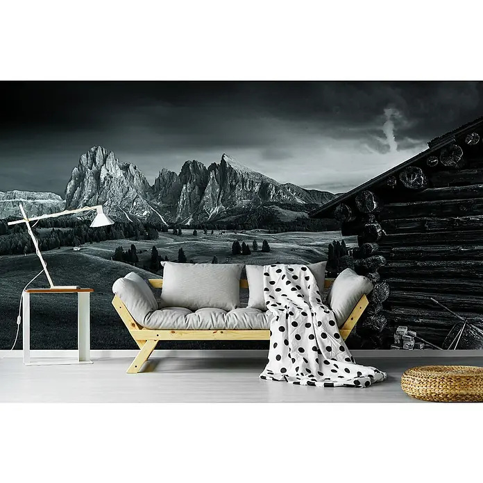 Papermoon Premium collection Fototapete Berghütte - B x H: 500 x 280 cm, Vlies - Wandbild mit Bergblick im Schwarz-Weiß-Design, das eine gemütliche Couch mit gepunkteter Decke und eine moderne Lampe ergänzt.