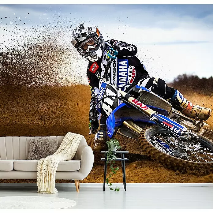 Papermoon Premium collection Fototapete Wüstenkönig - B x H: 250 x 186 cm, Vlies - Dynamische Tapete mit Motocross-Fahrer auf einem Dirtbike, der Schmutz aufwirbelt, hinter einem Sofa im Wohnzimmer installiert.