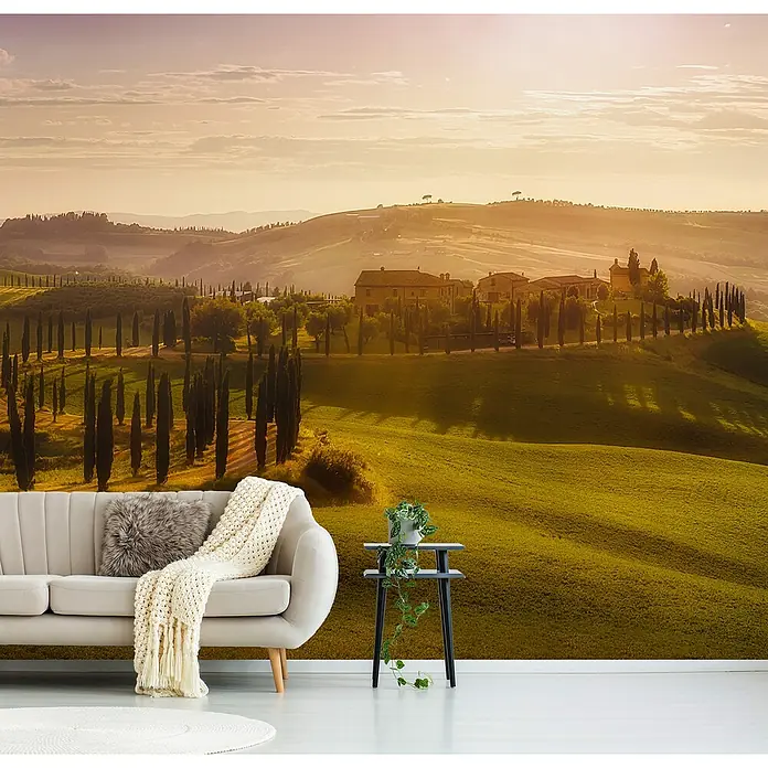 Papermoon Premium collection Fototapete Wellen des Lichts - B x H: 250 x 186 cm, Vlies - Gemütliches Wohnzimmer mit stilvollem Sofa und malerischer Landschaftstapete, die toskanische Hügel und Zypressen zeigt.