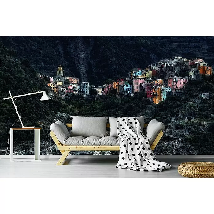 Papermoon Premium collection Fototapete Dorf-In Denfelsen - B x H: 250 x 186 cm, Vlies - Helles Holzsofa mit grauen Kissen, dekoriert mit einer weißen Decke mit schwarzen Punkten.