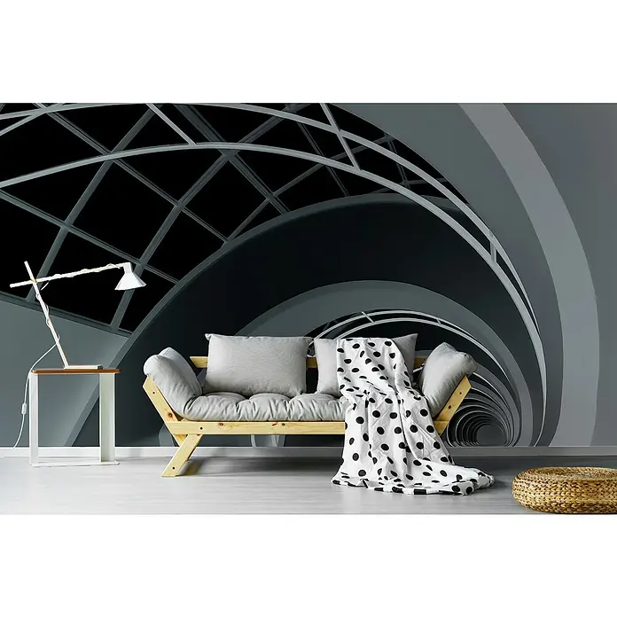 Papermoon Premium collection Fototapete Antwerpen-TreppeB x H: 350 x 260 cm, Vlies - Moderner Raum mit einem hellen Holzsofa, grauem Kissen und einer schwarz-weiß gepunkteten Decke vor einer abstrakten Wandgestaltung.