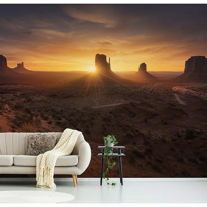 Papermoon Premium collection Fototapete Denkmal Sonnenaufgang - B x H: 200 x 149 cm, Vlies - Wohnzimmer mit Tapete mit Wüstenmotiv bei Sonnenuntergang. Ein Sofa und ein Tisch mit Pflanze vervollständigen die Einrichtung.
