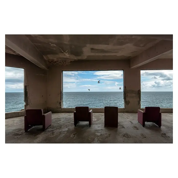 Papermoon Premium collection Fototapete Kino - B x H: 450 x 280 cm, Vlies - Blick aus einem unfertigen Raum auf das Meer mit Sesseln, die zum Verweilen einladen. Die Sessel bieten einen komfortablen Platz mit Meerblick.