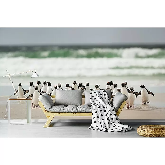 Papermoon Premium collection Fototapete Desembarco - B x H: 250 x 186 cm, Vlies - Holzsofa mit grauen Kissen, gepunkteter Decke, weißem Beistelltisch mit Lampe und geflochtenem Pouf in einem Raum mit Strandmotiv.