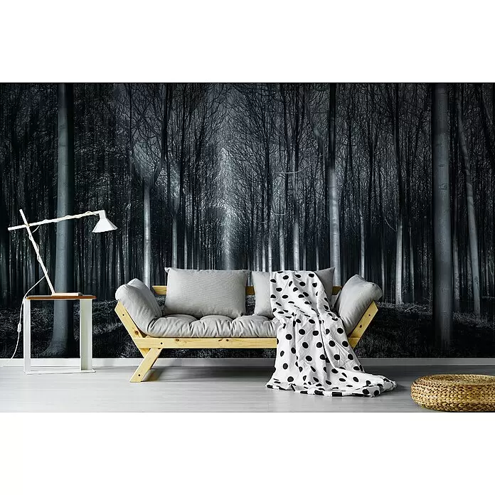 Papermoon Premium collection Fototapete In den Wal - B x H: 250 x 186 cm, Vlies - Ein helles Holzsofa mit grauen Kissen und einer gepunkteten Decke in einem modernen Wohnzimmer mit dunklem Wald-Wandbild.