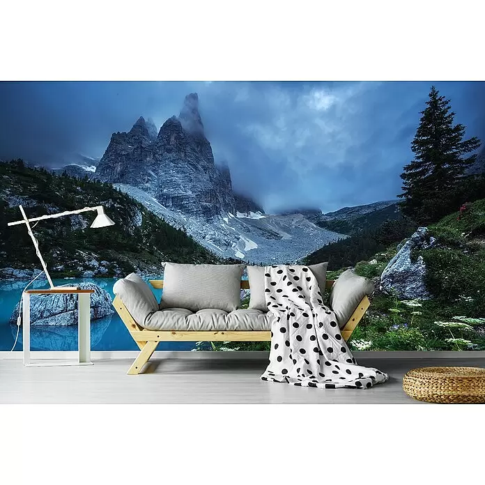 Papermoon Premium collection Fototapete Blaue Stunde des Lago di Sorapis Ventien - B x H: 350 x 260 cm, Vlies - Holzsofa mit grauen Kissen und schwarz-weiß gepunkteter Decke in einem Raum mit Naturwandbild.