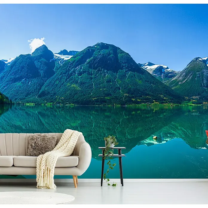 Papermoon Premium collection Fototapete Der Gletschersee - B x H: 250 x 186 cm, Vlies - Elegantes Wohnzimmer mit beigem Sofa, dekorativer Decke, Beistelltisch und Pflanzen vor einer ruhigen Bergkulisse.
