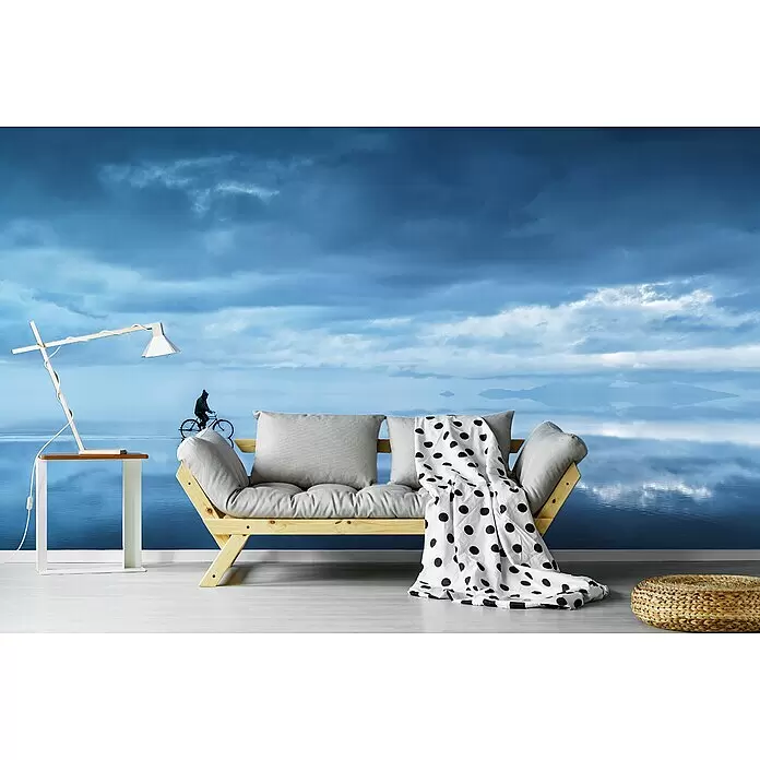 Papermoon Premium collection Fototapete In den Himmel gehen - B x H: 350 x 260 cm, Vlies - Holzsofa mit grauen Kissen und weißer Tupfen-Decke, vor einer atemberaubenden blauen See- und Himmel-Wandtapete.