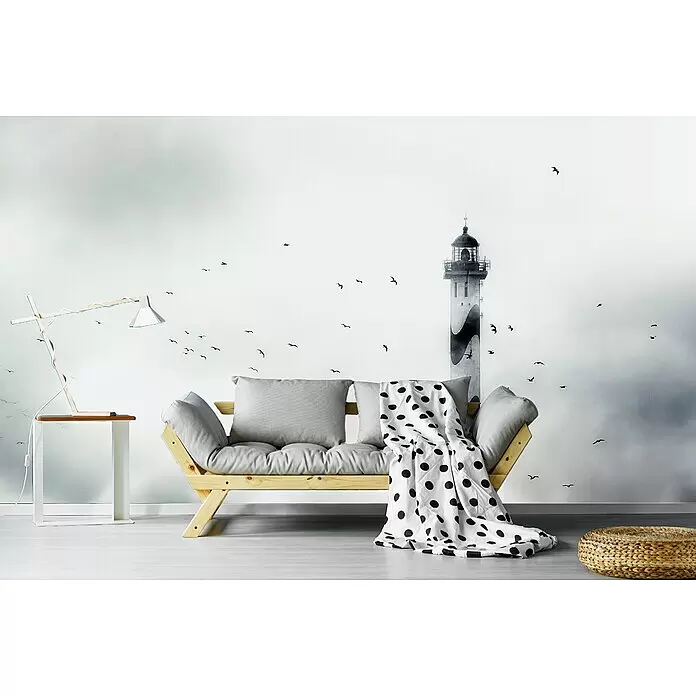 Papermoon Premium collection Fototapete Der Nebel - B x H: 400 x 260 cm, Vlies - Küstenwandbild mit Schwarz-Weiß-Leuchtturm und fliegenden Vögeln, als ruhige Kulisse für ein Holzsofa.